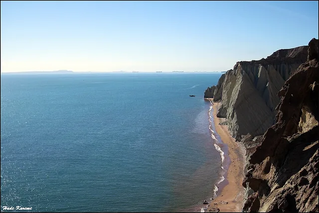 The coast of Hormuz Island in the Persian Gulf, with ships on the horizon